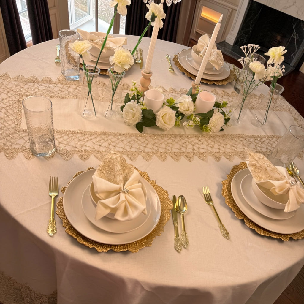 Luxury round dining table styled with Empire Lumina embroidered tablecloth, matching runner, napkins and elegant place settings.