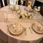 Luxury round dining table styled with Empire Lumina embroidered tablecloth, matching runner, napkins and elegant place settings.