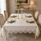 Luxury off-white stain-resistant Turkish linen tablecloth set elegantly displayed on a rectangular dining table with embroidered lace details, white dinnerware, gold candlesticks, and a sophisticated luxury dining room.